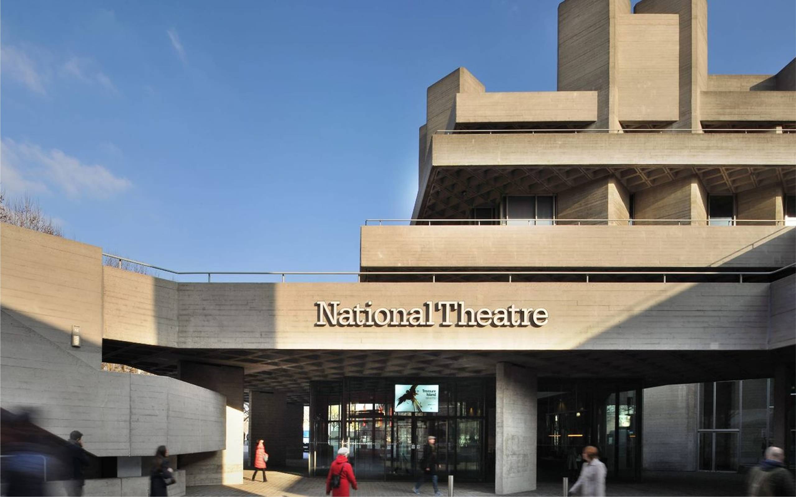 Photograph of the National Theatre building on the Southbank. Taken from the outside, the words 'National Theatre' are clearly displayed across the building's iconic concrete structure.